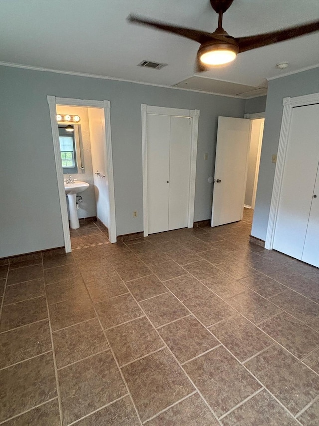 unfurnished bedroom featuring ceiling fan and connected bathroom