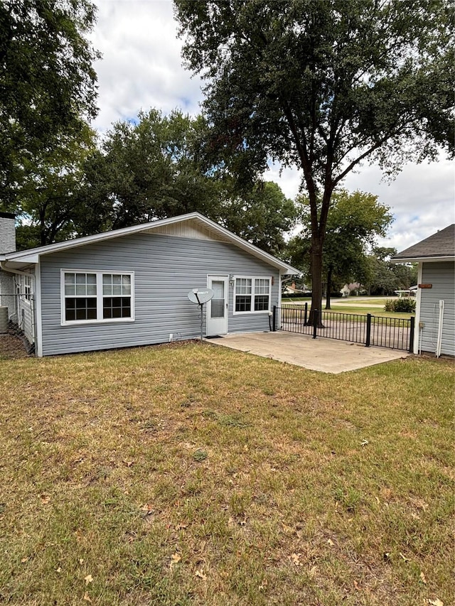 rear view of property featuring a yard and a patio