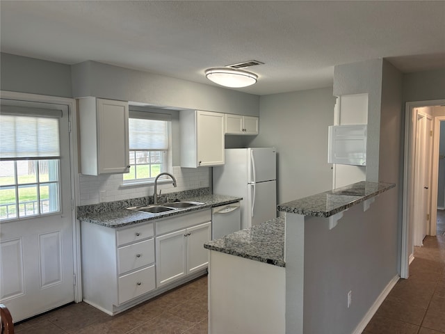 kitchen with sink, white cabinets, white appliances, and decorative backsplash