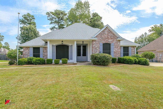 view of front of house with french doors, brick siding, roof with shingles, and a front yard