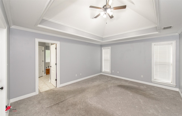 spare room featuring light colored carpet, ceiling fan, ornamental molding, and a raised ceiling