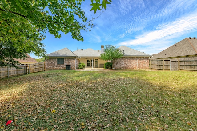 back of property with a patio area and a yard