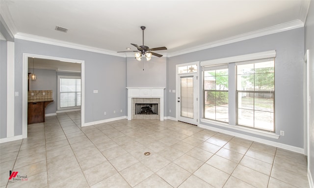 unfurnished living room featuring crown molding, ceiling fan, light tile patterned floors, and a fireplace