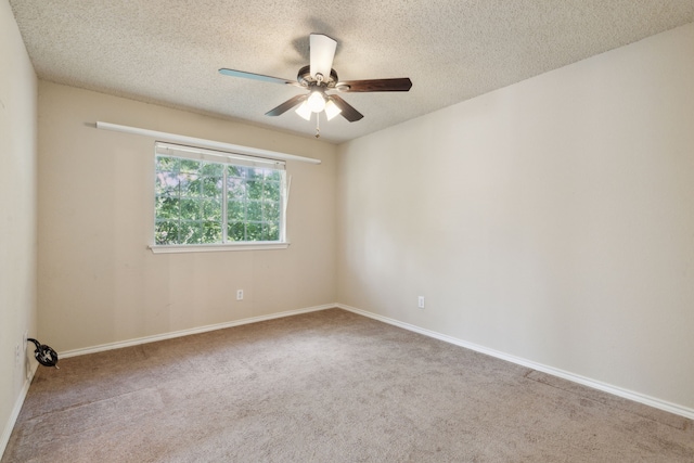 carpeted spare room featuring a textured ceiling and ceiling fan