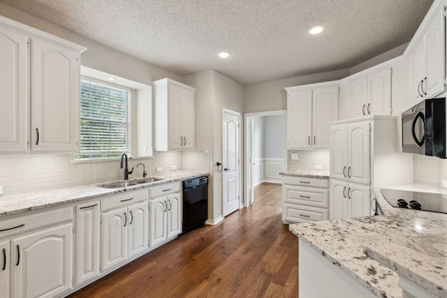 kitchen featuring dark hardwood / wood-style flooring, black appliances, sink, light stone counters, and white cabinets