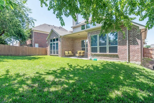 back of property featuring a yard and a patio area