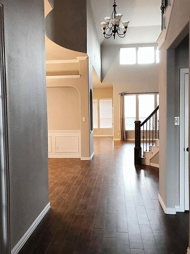 foyer entrance with a chandelier, a high ceiling, and dark hardwood / wood-style floors