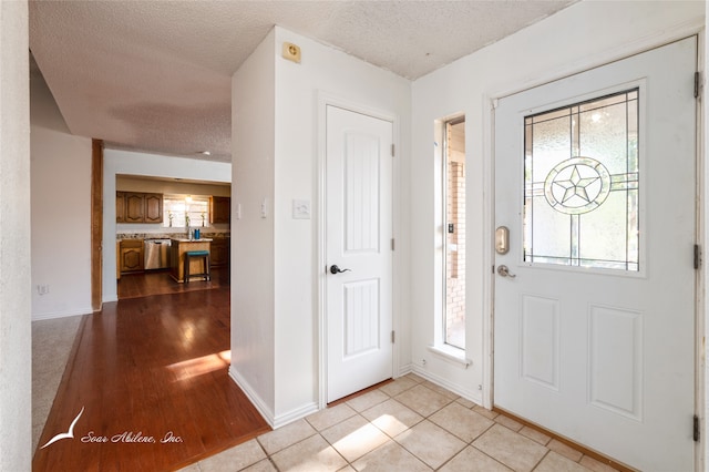 foyer featuring a textured ceiling and light hardwood / wood-style flooring