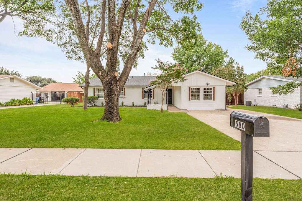 ranch-style house with central AC unit and a front lawn