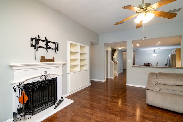 living room featuring ceiling fan, built in features, and dark hardwood / wood-style flooring