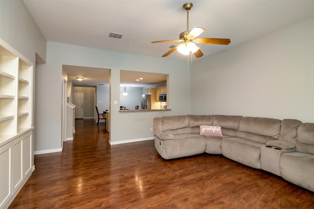 unfurnished living room featuring ceiling fan and dark hardwood / wood-style flooring