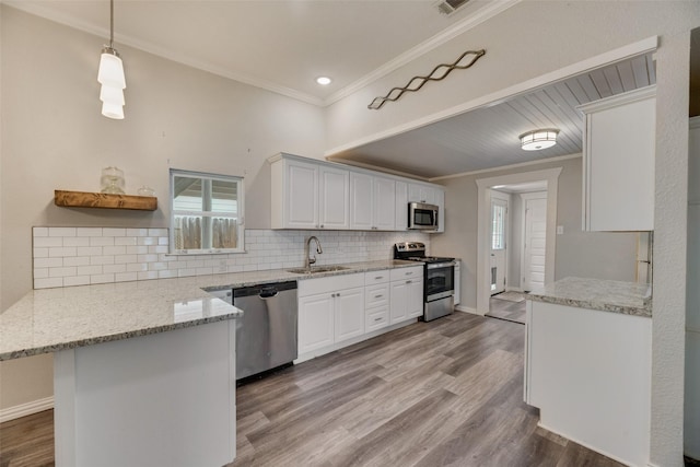 kitchen with tasteful backsplash, appliances with stainless steel finishes, ornamental molding, a sink, and a peninsula