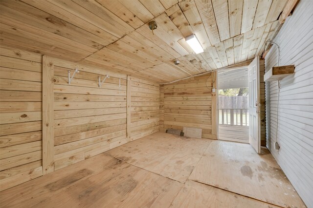 interior space featuring wood ceiling, lofted ceiling, and wooden walls