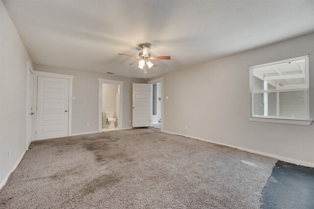 unfurnished bedroom with ensuite bath, a textured ceiling, ceiling fan, and carpet flooring