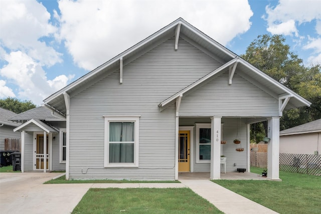 bungalow-style house with fence and a front lawn