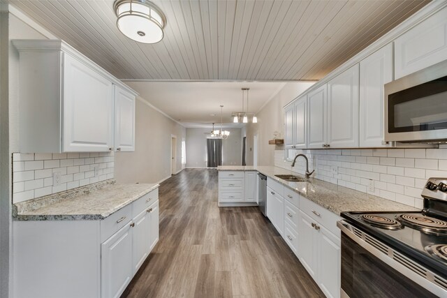 kitchen featuring white cabinetry, wood-type flooring, kitchen peninsula, and stainless steel appliances