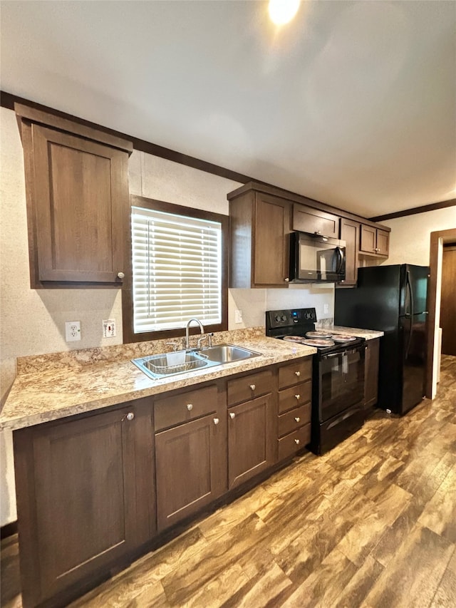 kitchen featuring black appliances, light hardwood / wood-style floors, ornamental molding, sink, and dark brown cabinetry