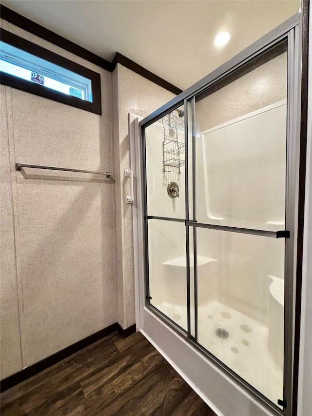 bathroom featuring a shower with door and hardwood / wood-style flooring