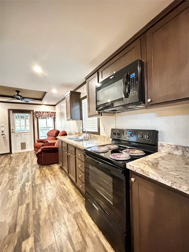 kitchen featuring light hardwood / wood-style floors, sink, black appliances, dark brown cabinets, and ceiling fan