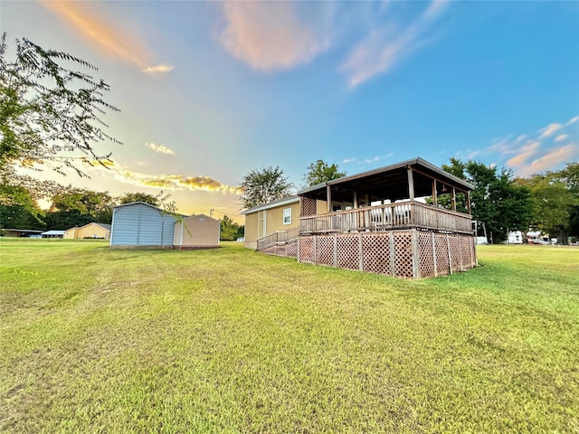 yard at dusk featuring a wooden deck