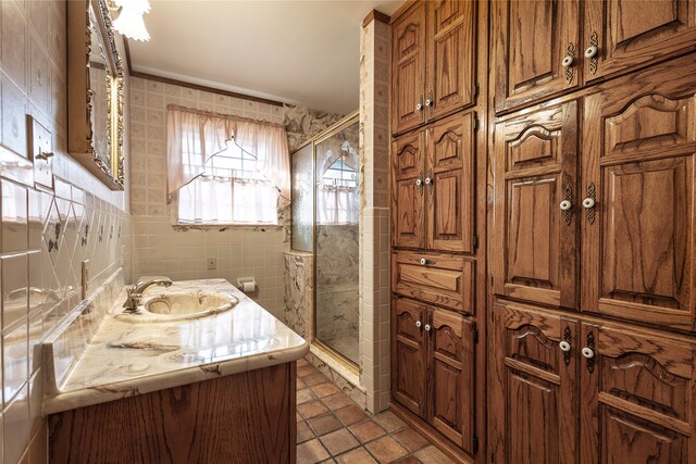 bathroom featuring tile walls, vanity, tile patterned flooring, and a shower with shower door