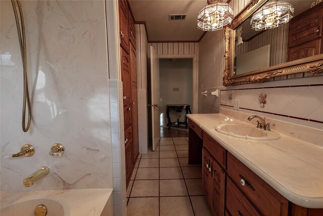 bathroom featuring a bathing tub, ornamental molding, vanity, and tile patterned floors