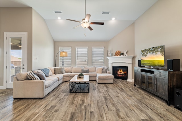 living room with light hardwood / wood-style floors, high vaulted ceiling, and ceiling fan