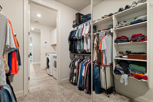 walk in closet featuring light hardwood / wood-style floors and washing machine and clothes dryer