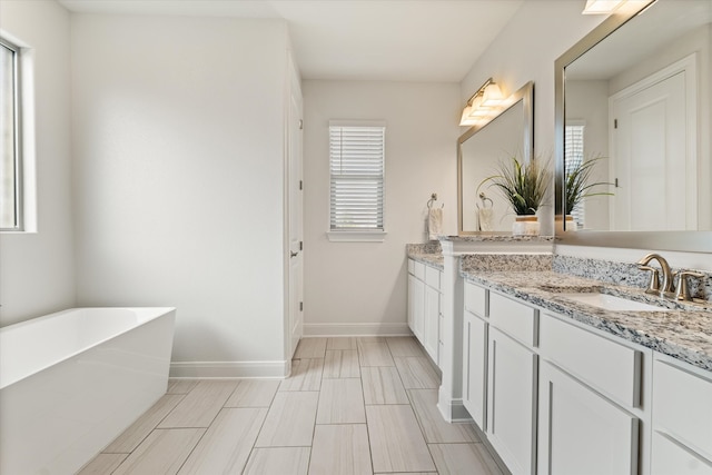 bathroom with vanity and a tub