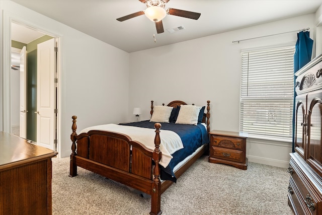 carpeted bedroom featuring multiple windows and ceiling fan