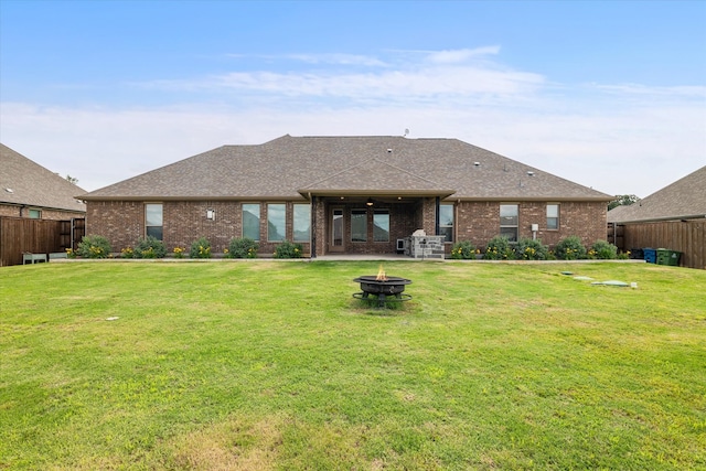 rear view of house with a patio, a yard, and an outdoor fire pit