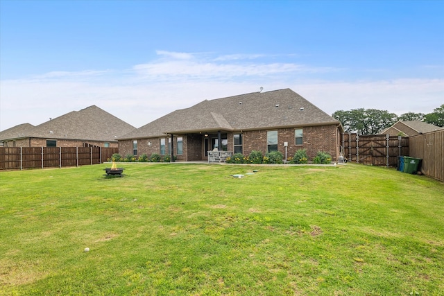 rear view of property featuring a lawn