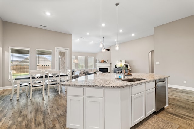 kitchen featuring sink, white cabinets, a healthy amount of sunlight, and an island with sink