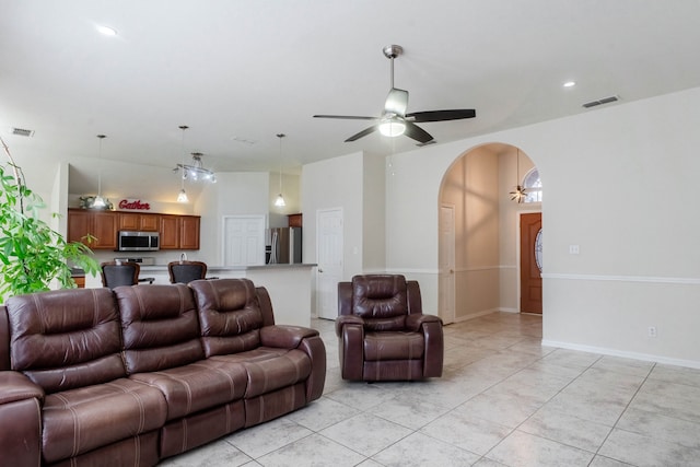 tiled living room featuring ceiling fan with notable chandelier