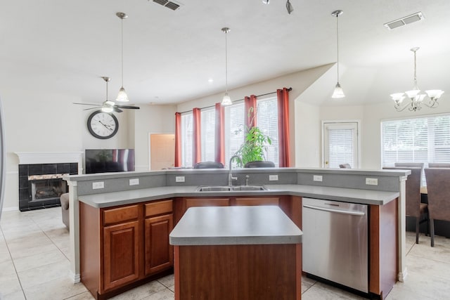 kitchen featuring dishwasher, a fireplace, ceiling fan with notable chandelier, pendant lighting, and a kitchen island