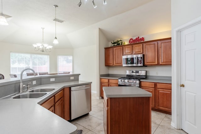 kitchen with hanging light fixtures, an inviting chandelier, appliances with stainless steel finishes, lofted ceiling, and a kitchen island