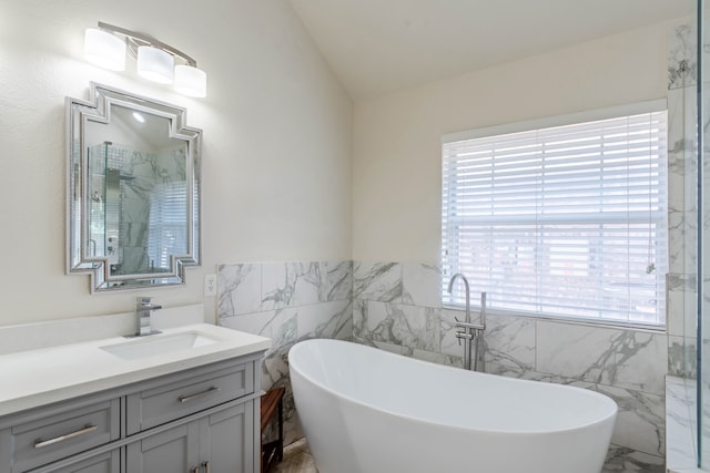 bathroom featuring vanity, vaulted ceiling, tile walls, and plus walk in shower