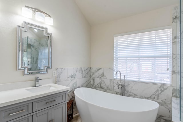 7525 Juliet Ln, Fort Worth, TX 76137 - full bathroom with tile walls, marble finish floor, vanity, vaulted ceiling, and a freestanding bath