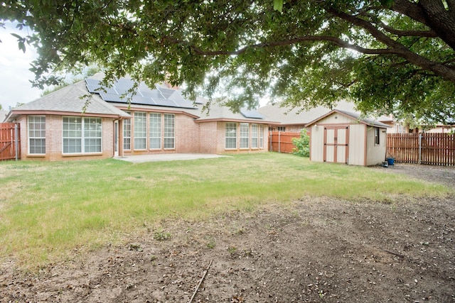 7525 Juliet Ln, Fort Worth, TX 76137 - back of property featuring roof mounted solar panels, an outbuilding, a fenced backyard, and a shed