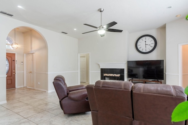 7525 Juliet Ln, Fort Worth, TX 76137 - living area with visible vents, ceiling fan, arched walkways, light tile patterned floors, and a tile fireplace