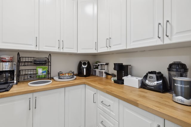 kitchen with wooden counters and white cabinets