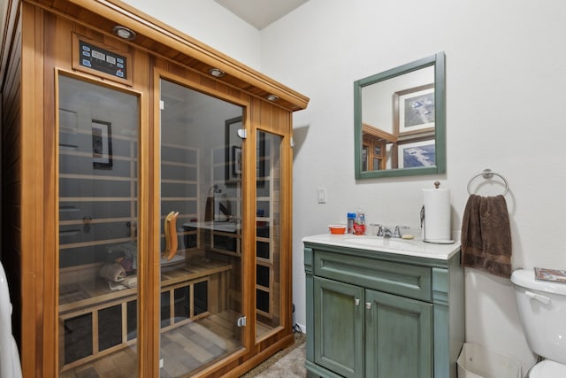 bathroom with vanity, toilet, and a shower with door