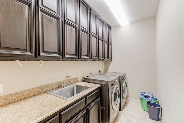 clothes washing area with light tile patterned floors, separate washer and dryer, cabinets, and sink