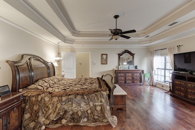 bedroom with crown molding, a tray ceiling, dark hardwood / wood-style flooring, and ceiling fan