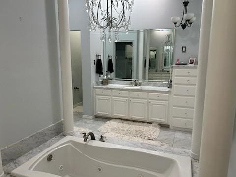 bathroom with a tub to relax in, a chandelier, and vanity