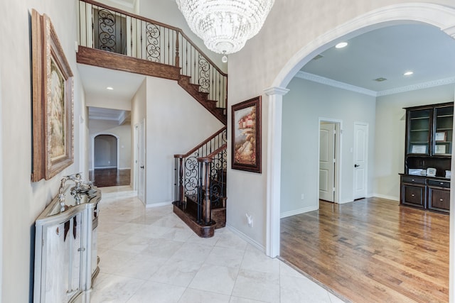 foyer entrance featuring an inviting chandelier, light wood-type flooring, and crown molding