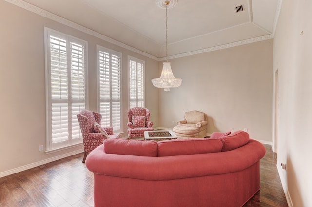 living room with an inviting chandelier, ornamental molding, and dark wood-type flooring