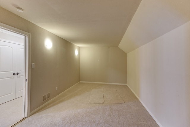 additional living space featuring light carpet and lofted ceiling