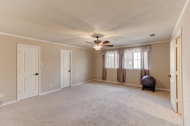 carpeted spare room featuring ceiling fan and crown molding