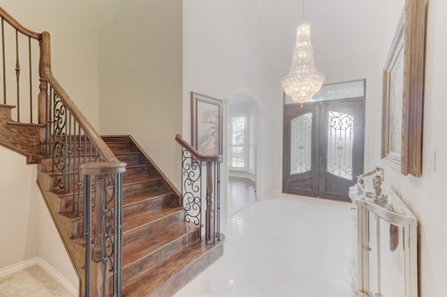 entryway featuring french doors, a notable chandelier, and tile patterned floors